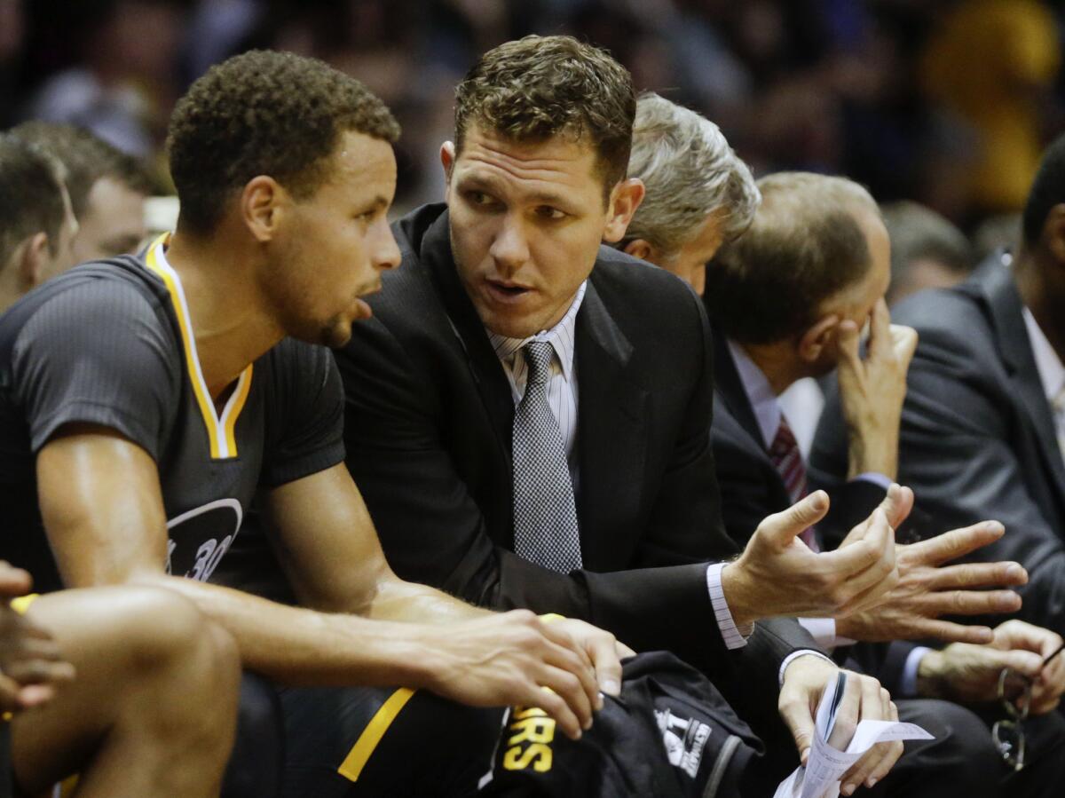 Warriors interim coach Luke Walton talks with guard Stephen Curry during the first half of a game on Oct. 17.
