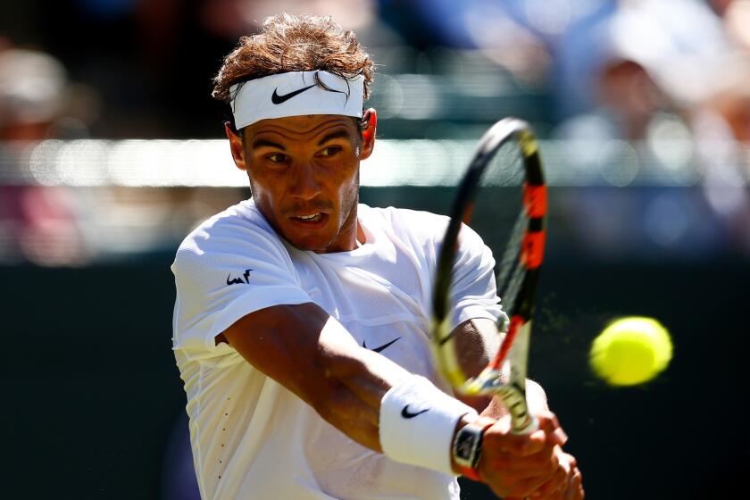 Rafal Nadal hits a return during his first-round match against Thomaz Bellucci at Wimbledon on June 30, 2015.