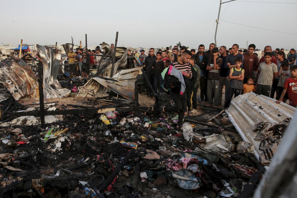Palestinians look at the destruction after an Israeli strike where displaced people were staying in Rafah, Gaza Strip.