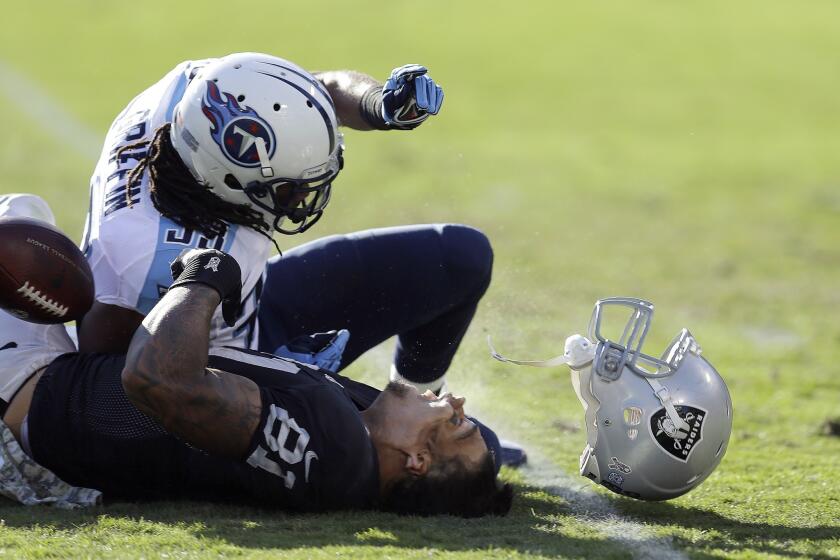 Oakland Raiders tight end Mychal Rivera, bottom, loses his helmet after being hit by Tennessee Titans free safety Michael Griffin during a game in November. Rivera suffered a concussion on the play.