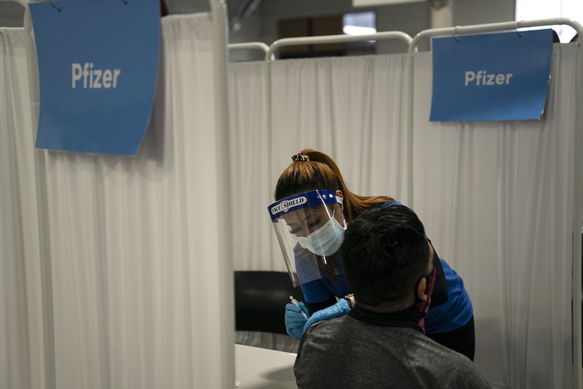 A nurse administers the Pfizer COVID-19 vaccine to a patient in Santa Ana