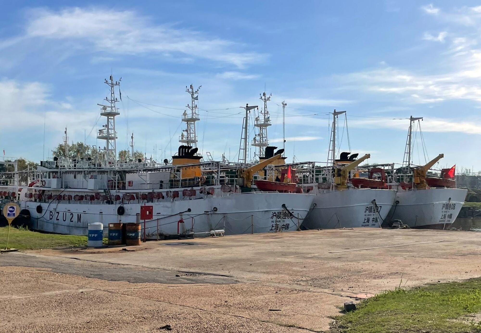 A row of white fishing boats at a dock