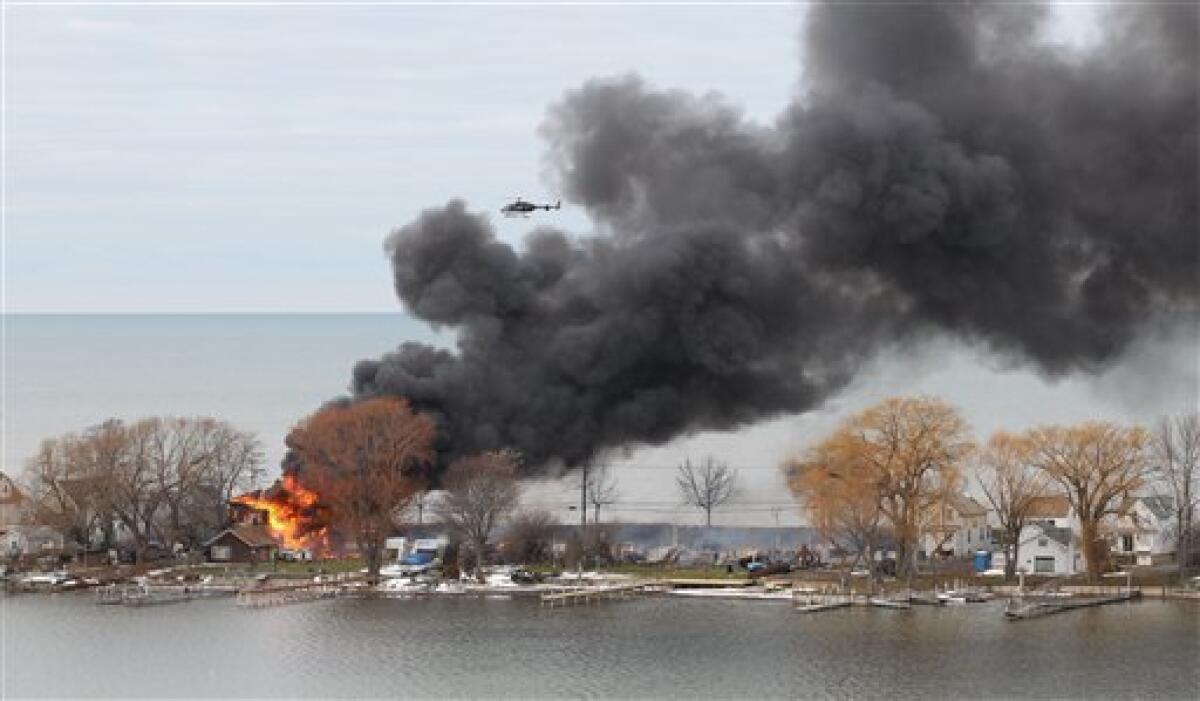 A house burns in Webster, N.Y., after an ex-convict set a car ablaze in his lakeside neighborhood to lure firefighters, then opened fire. He killed two and seriously wounded two more before killing himself.