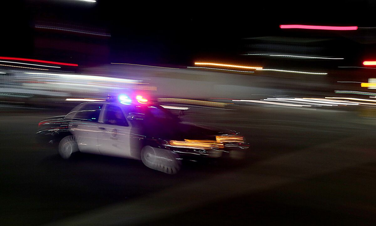 An LAPD patrol car rushes through the intersection of La Brea Avenue and Venice Boulevard in April.