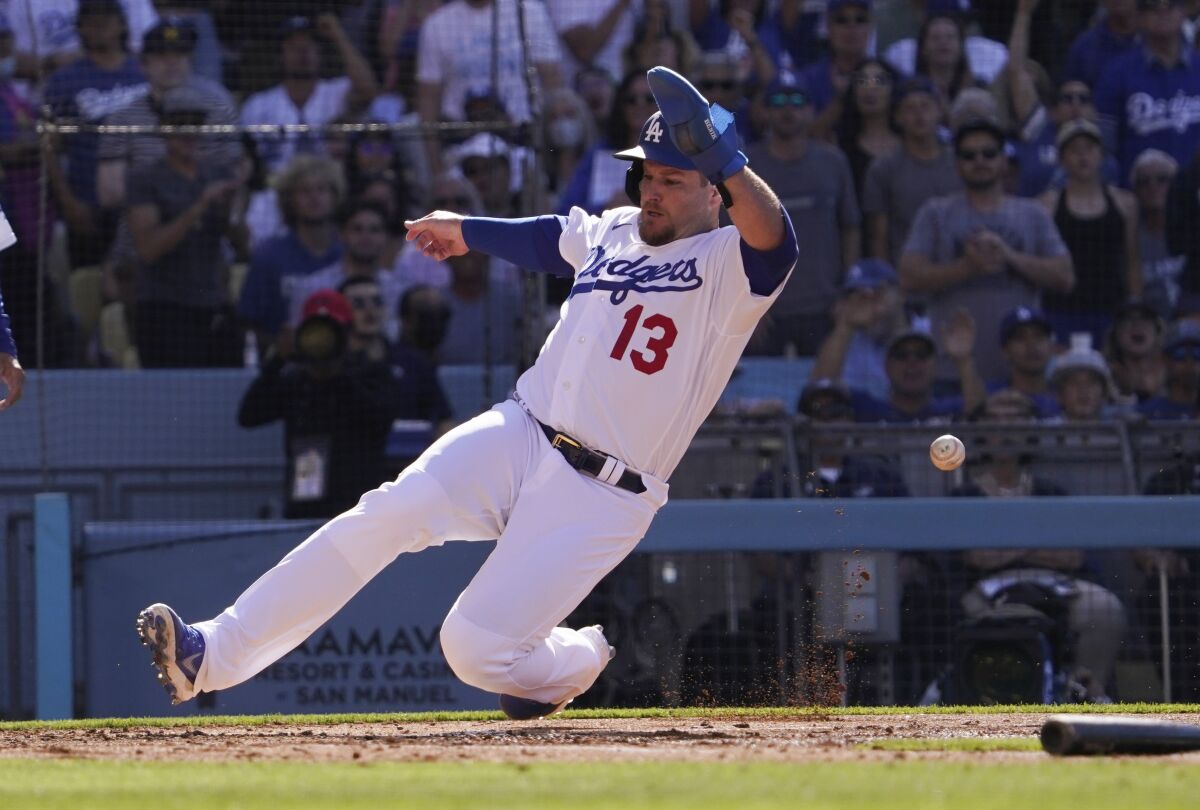 Dodgers baserunner Max Muncy scores on double by Justin Turner against the Cleveland Guardians on Saturday.