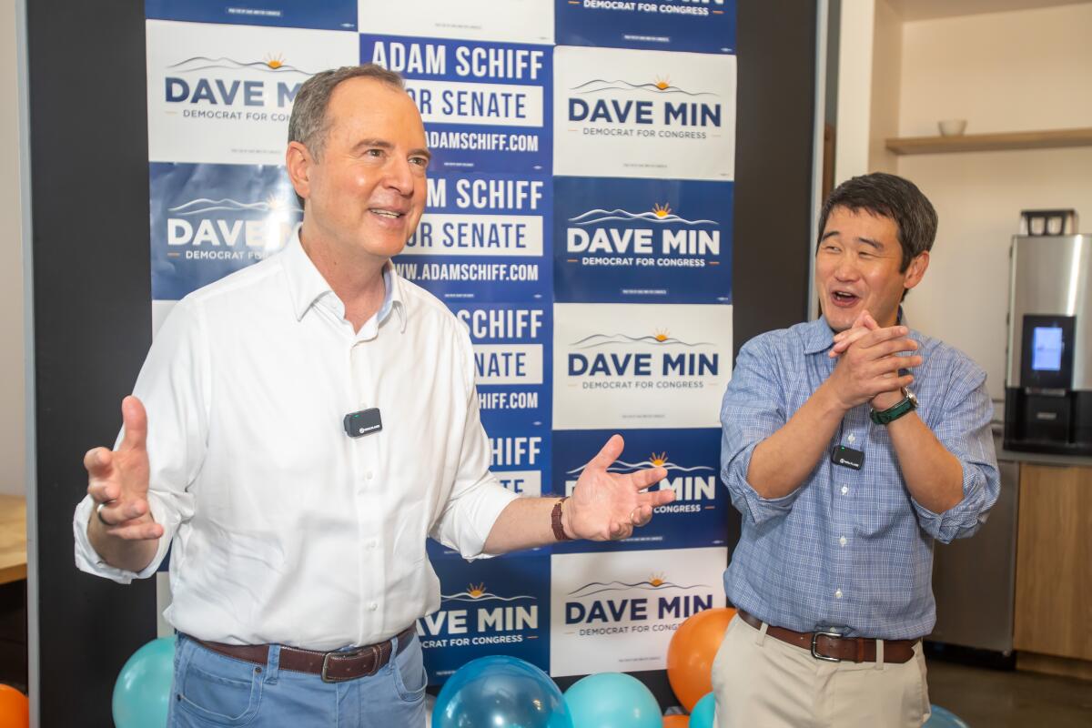 Candidate Dave Min claps as Rep. Adam B. Schiff speaks during a campaign event.