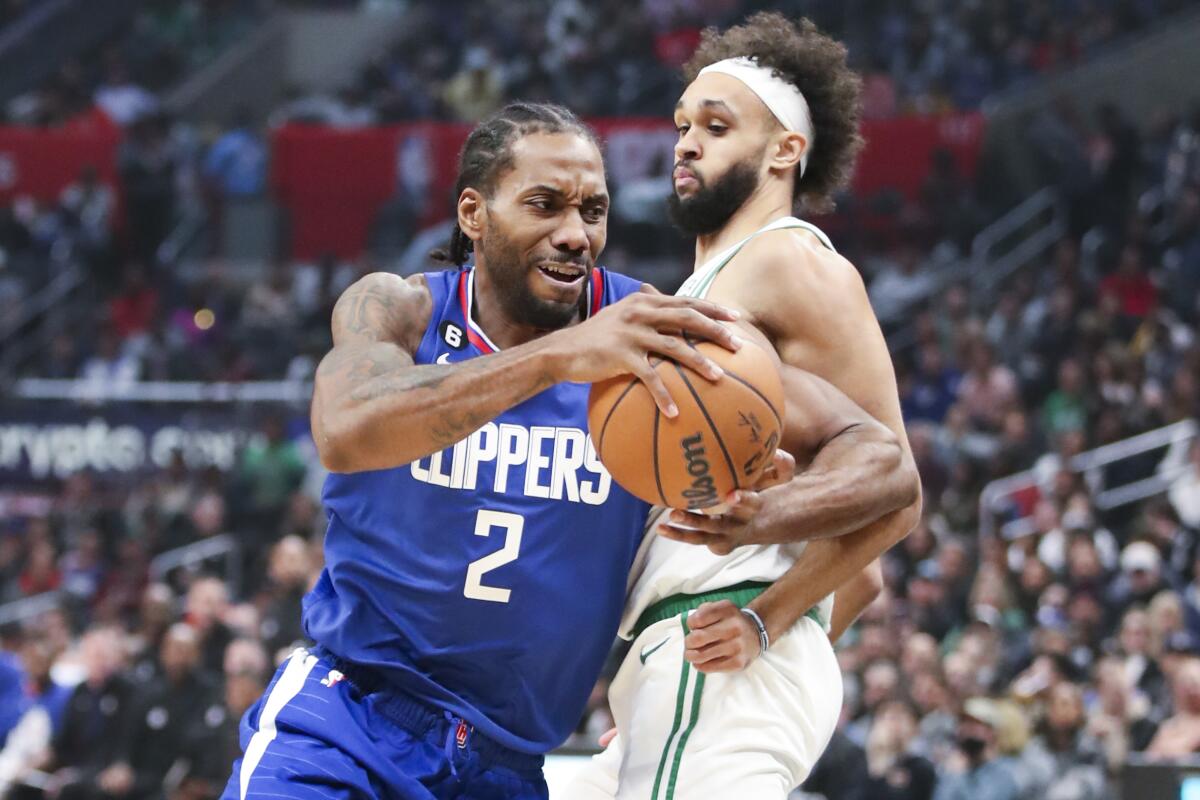 Clippers forward Kawhi Leonard drives to the basket past Boston Celtics guard Derrick White.