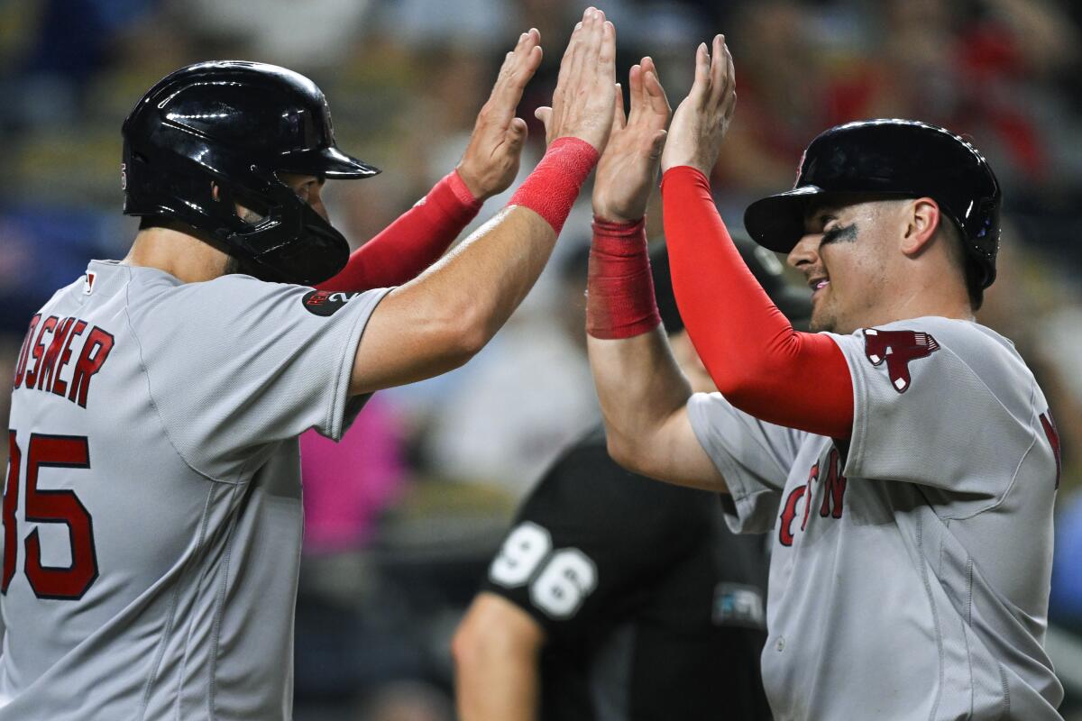 Boston Red Sox's Eric Hosmer, left, and Reese McGuire, celebrate after scoring against the Kansas City Royals on a double by Jarren Duran during the eighth inning of a baseball game Friday, Aug. 5, 2022, in Kansas City, Mo. (AP Photo/Reed Hoffmann)