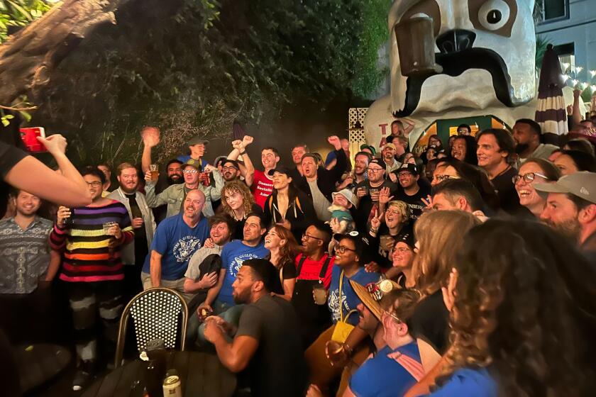 Hollywood workers celebrate a tentative WGA-AMPTP contract agreement outside the North Hollywood bar Idle Hour.