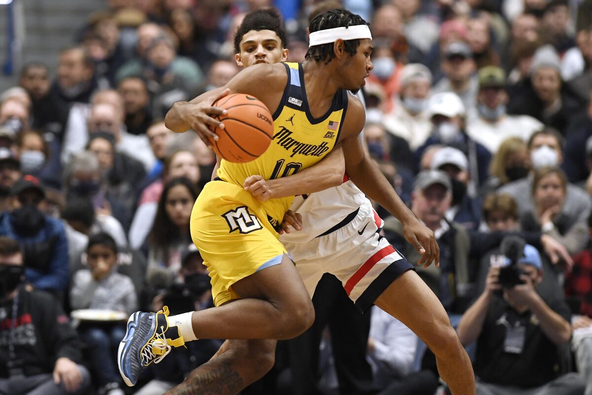 Marquette's Justin Lewis (10) is guarded by Connecticut's Andre Jackson in the first half of an NCAA college basketball game, Tuesday, Feb. 8, 2022, in Hartford, Conn. (AP Photo/Jessica Hill)