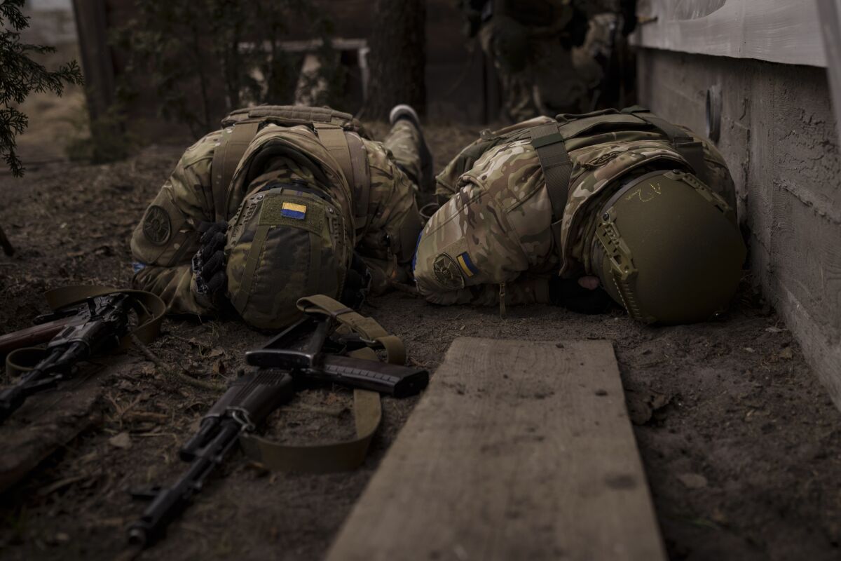 Soldiers lie face down.