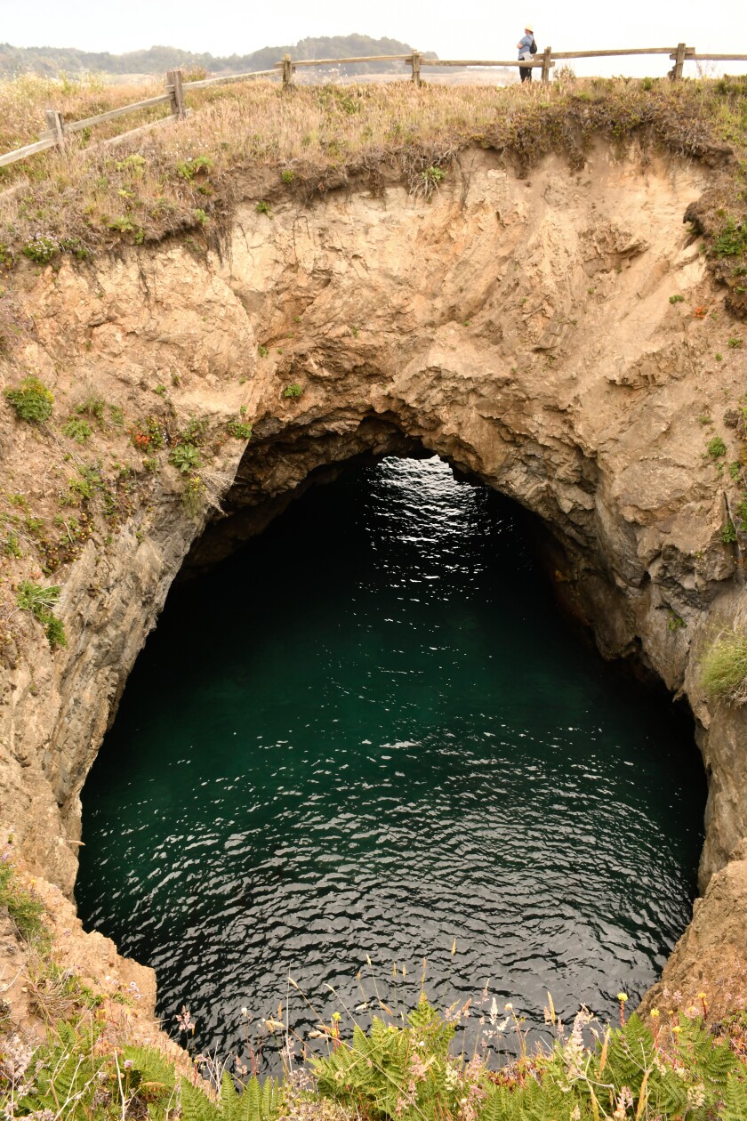A cliff with a cave filled with water
