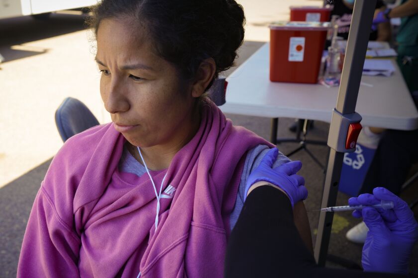 San Diego, CA - March 26: At the mobile vaccine clinic set up at City Heights on Saturday, March 26, 2022 in San Diego, CA., Nancy Vidal, 33 from City Heights received her first dose of the COVID vaccine. Vida said she had COVID last year in 2021, and said she waited so long to get vaccinated because she was nervous and wanted to make the decision her self. (Nelvin C. Cepeda / The San Diego Union-Tribune)