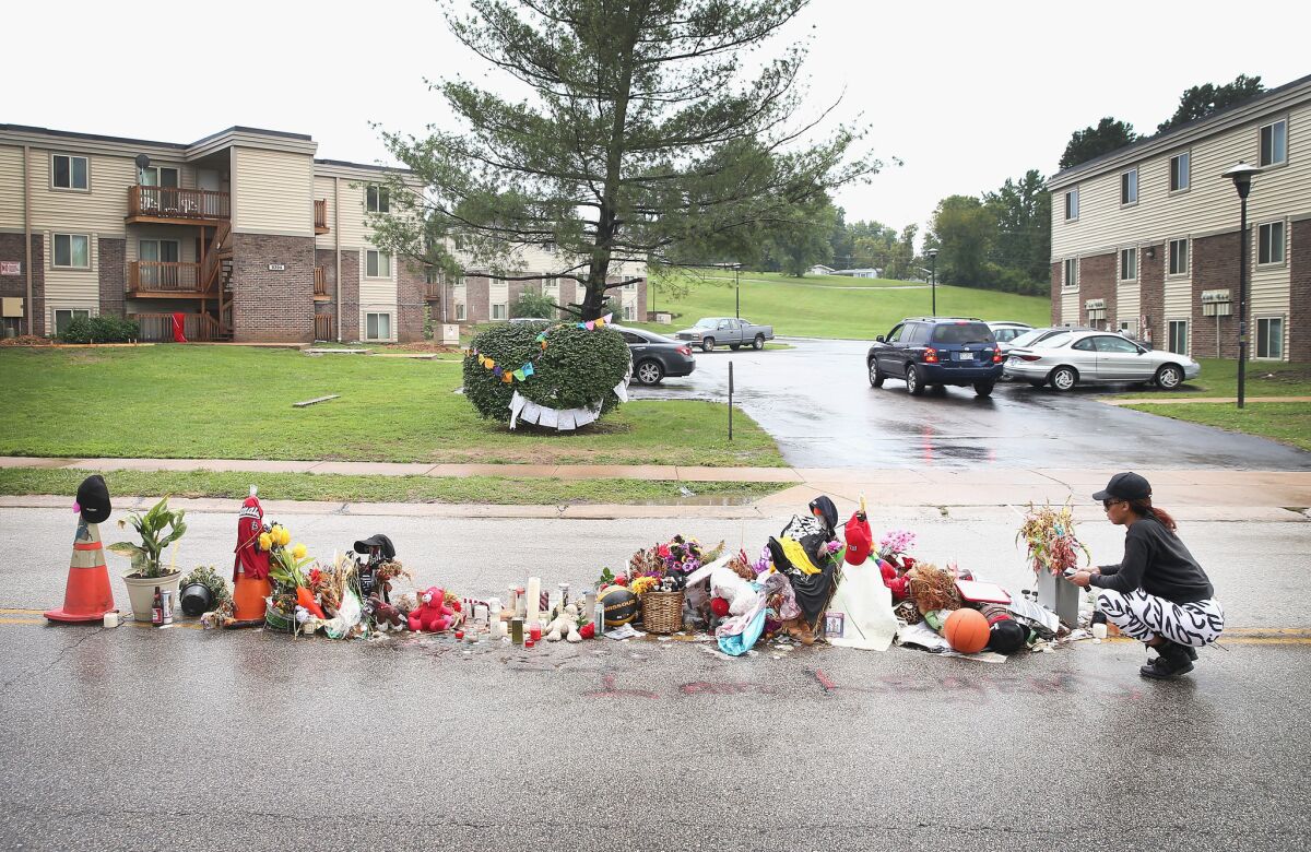 Tamika Staton leaves a message at a memorial that continues to grow in the middle of the road where Michael Brown died after being shot by Ferguson police Officer Darren Wilson about a month ago.