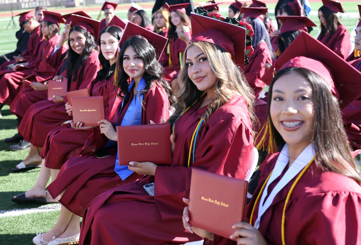 Graduates smile as they show off their diplomas during the Ocean View graduation ceremony on Wednesday.