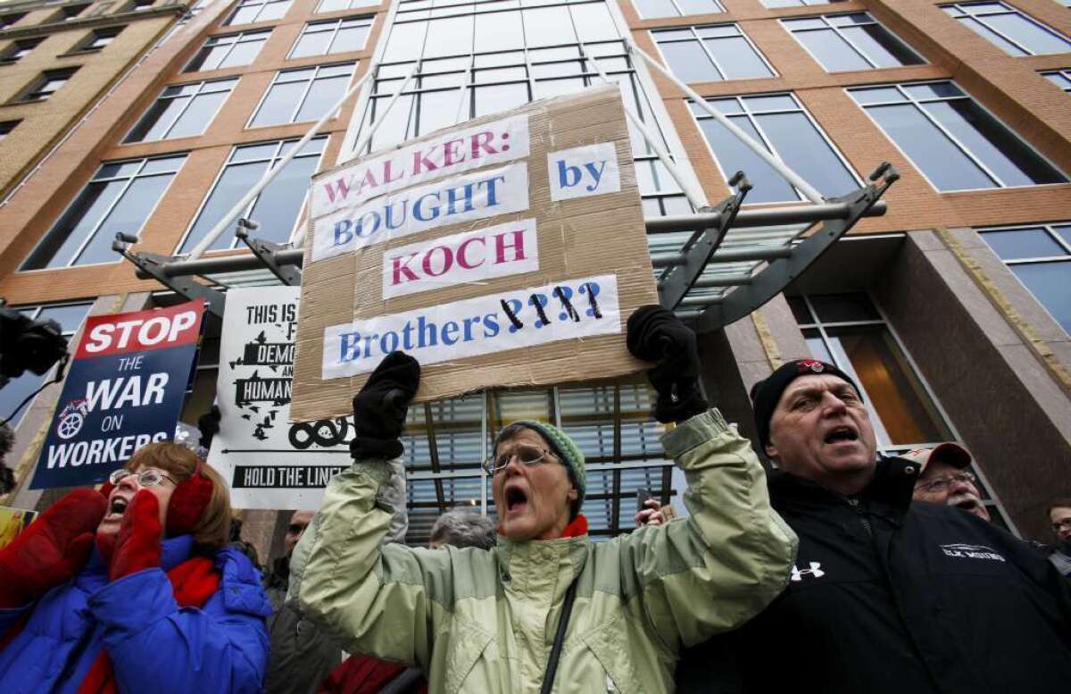 Jane Pederson, center, of Menomonie, Wis., protests in front of the offices of Koch Industries in Madison, Wis., in 2011.