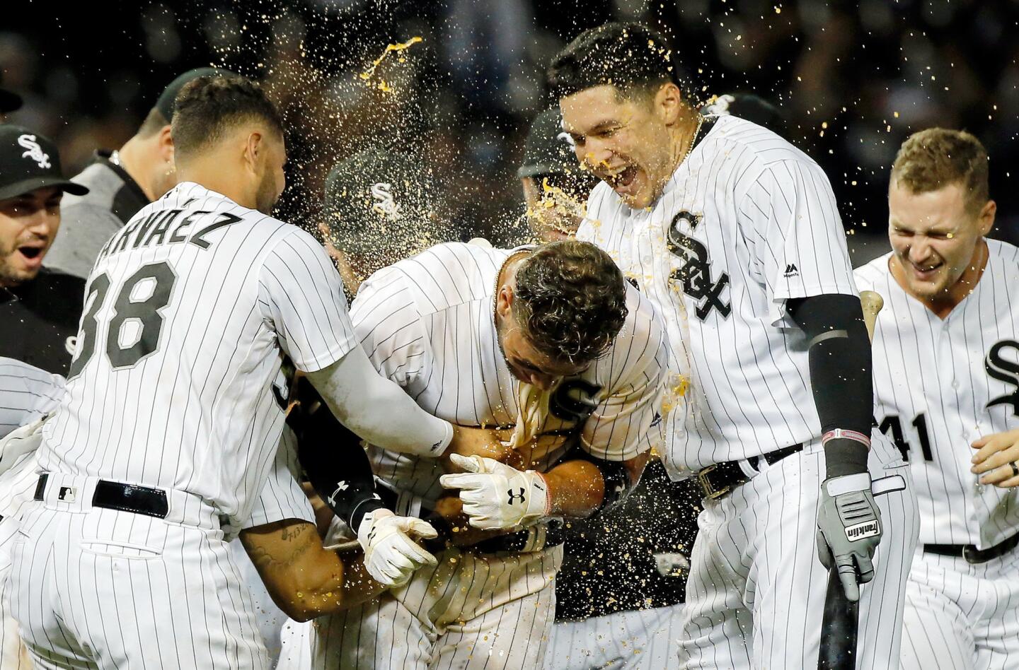 Omar Narvaez, left, and Avisail Garcia, right, celebrate with Yoan Moncada after he hit a walkoff RBI single against the Astros during the eleventh inning at Guaranteed Rate Field on Aug. 10, 2017.
