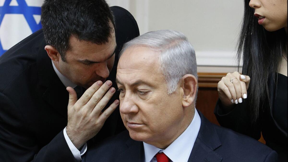Spokesman David Keyes, left, leans in to speak to Israeli Prime Minister Benjamin Netanyahu in a July meeting of the Cabinet in his Jerusalem office.
