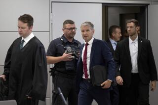 Björn Höcke, center, chairman of the Thuringian AfD, enters the courtroom of the district court shortly before the verdict is announced after his lawyer Florian Gempe, left, in Halle, Germany, Monday July 1, 2024. Höcke was convicted for the second time Monday of knowingly using a Nazi slogan at a political event. (Hendrik Schmidt/dpa via AP)
