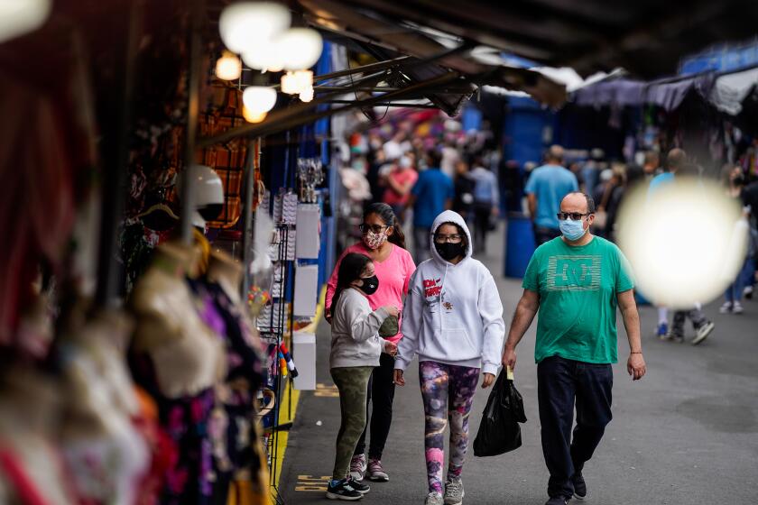 SANTA FE SPRINGS, CA - JUNE 20: People walk the aisles of the Santa Fe Springs Swap Meet on Saturday, June 20, 2020 in Santa Fe Springs, CA. Swap Meets across the Southland are struggling to bounce back after finally re-opening amid the ongoing Coronavirus pandemic. (Kent Nishimura / Los Angeles Times)