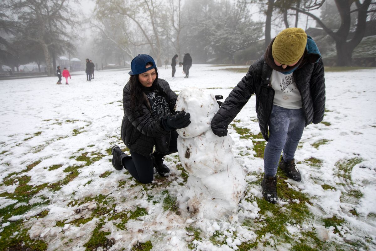 Lusin Torosyan, à gauche, et son enfant, Shant Yedigaryan, 12 ans, construisent un bonhomme de neige à Dunsmore Park à Glendale.