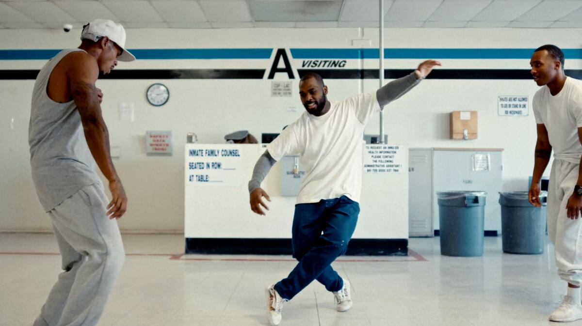 People dancing in an open room, dressed in white. 