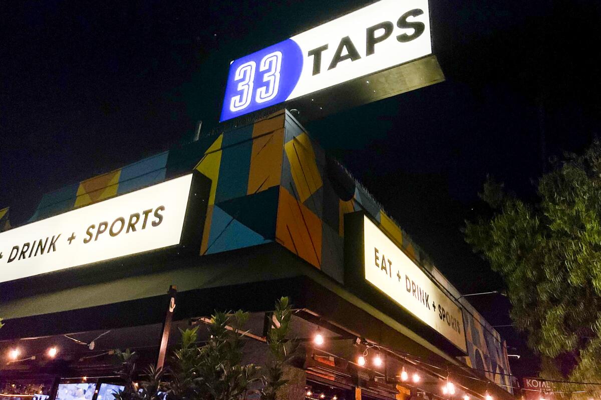 The colorful exterior of a bar with a lighted sign that reads 33 Taps.