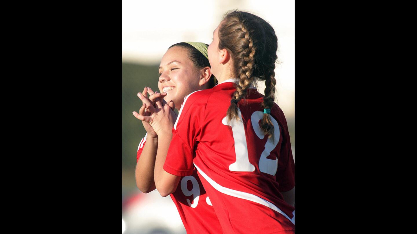 Burroughs' Mireya Gonzalez congratulates teammate Maddy Sena for scoring the games second goal to go up 2-0 against Burbank in a rival Pacific League girls' soccer game at Burbank High School on Thursday, Feb. 11, 2016. Burroughs got ahead with a 2-0 lead that Burbank tied in the final five minutes.