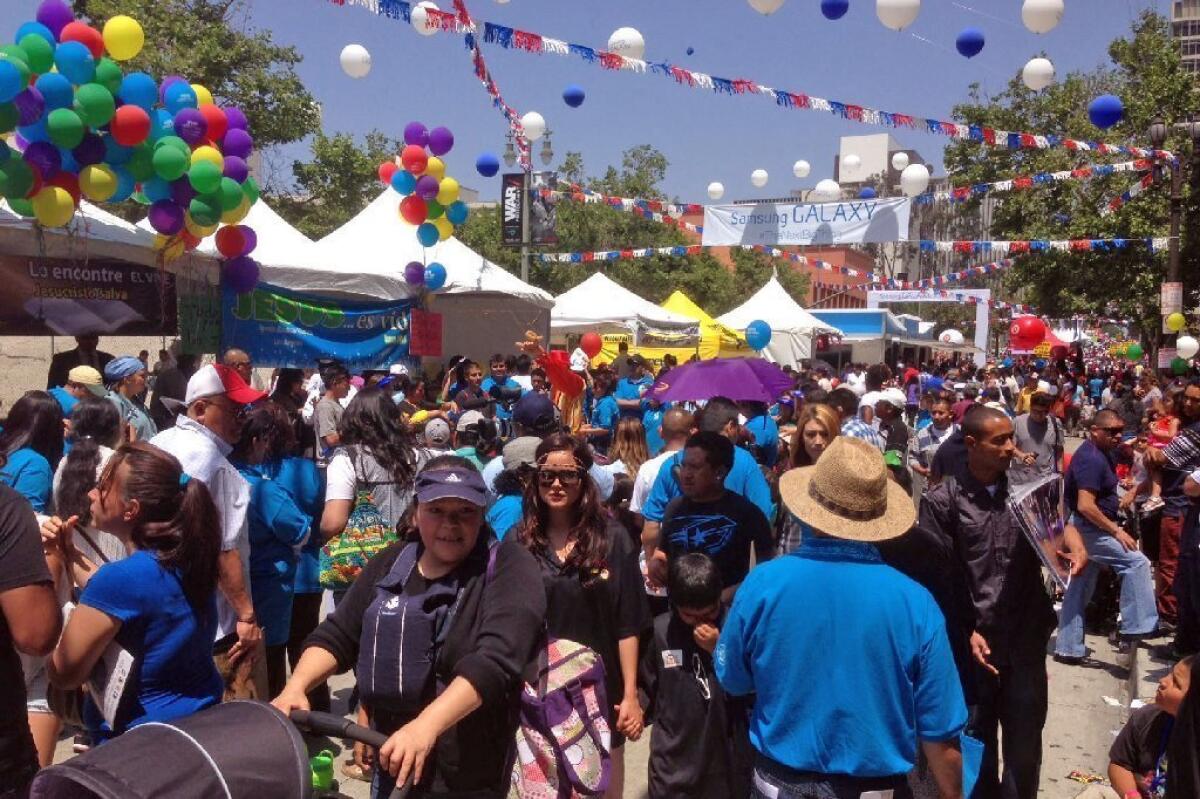 On a sunny Sunday, families enjoy Fiesta Broadway in downtown Los Angeles.