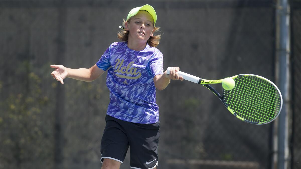 Perry Di Giulio of Newport Beach competes against Dominique Rolland in a 12s division quarterfinal match of the Southern California Junior Sectional tennis tournament at Los Caballeros Sports and Racquet Club in Fountain Valley on Saturday.