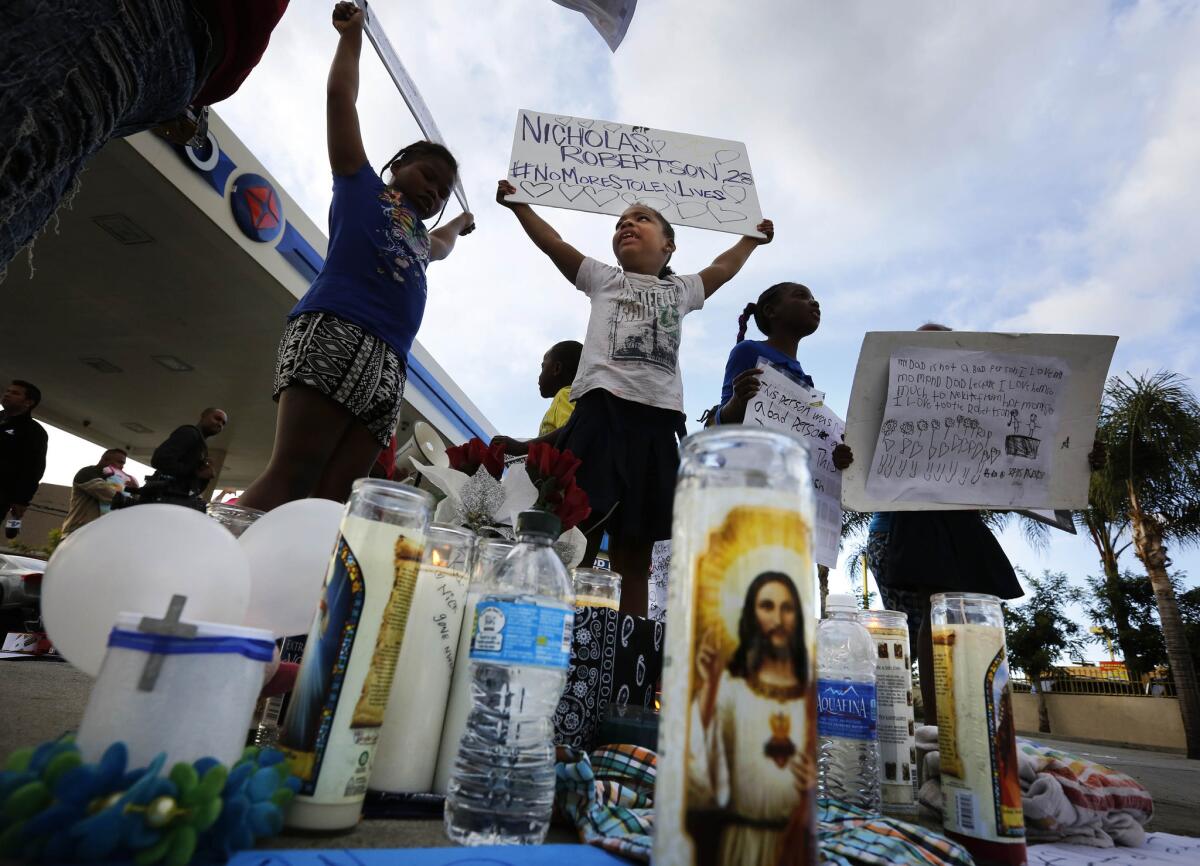 Mourners gather at the site where Nicholas Robertson was shot by Los Angeles County sheriff's deputies.