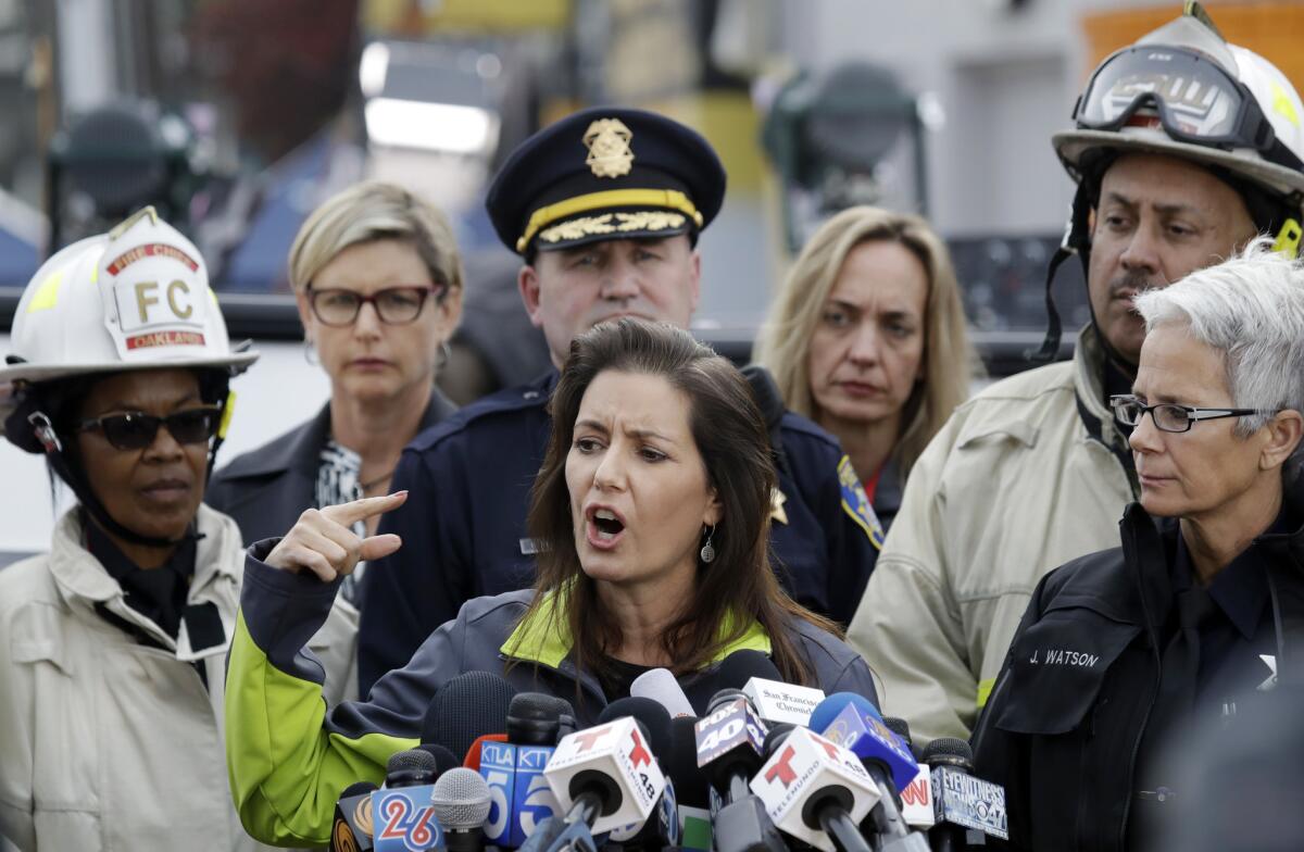 Mayor Libby Schaaf, center, is flanked by emergency personnel during a press conference near the site of the Ghost Ship fire on Dec. 5