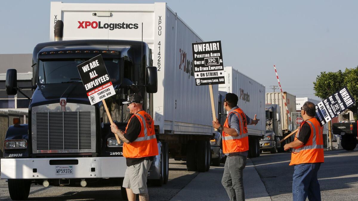 Port truck drivers picket at XPO Logistics in Commerce in 2017. On Saturday, Gov. Jerry Brown signed a bill that holds retailers jointly liable for labor law violations at California ports.