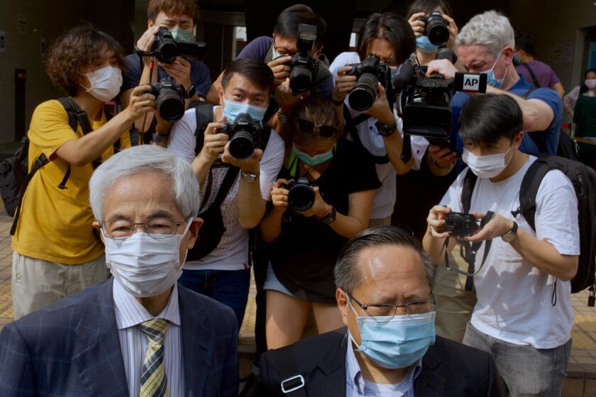 Pro-democracy lawmaker Martin Lee, left, and Albert Ho arrive at a court in Hong Kong Thursday, April 1, 2021. Seven pro-democracy advocates, including media tycoon Jimmy Lai and veteran of the city's democracy movement Lee, are expected to be handed a verdict for organizing and participating in an illegal assembly during massive anti-government protests in 2019 as Hong Kong continues its crackdown on dissent. (AP Photo/Vincent Yu)