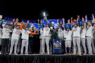 The Houston Astros celebrate with the American League Championship trophy after defeating the New York Yankees in Game 4 