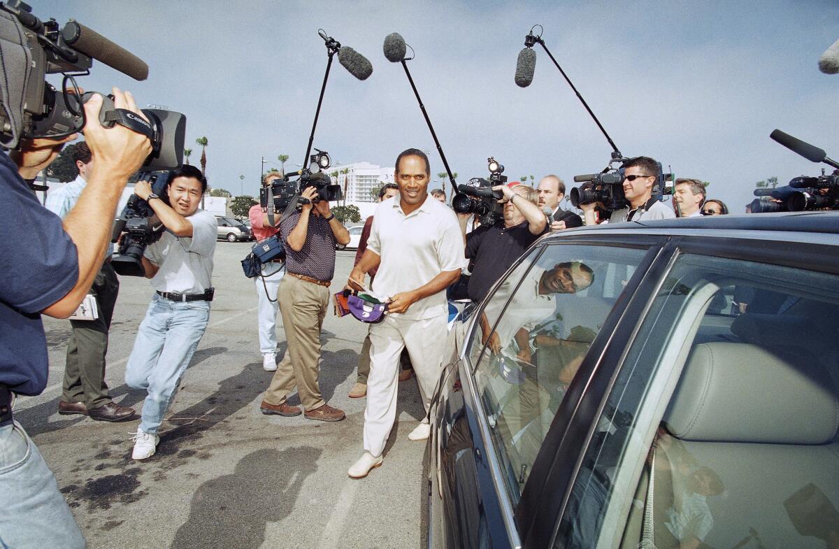 O.J. Simpson is surrounded by media as he departs Santa Monica Superior Court on Thursday, May 15, 1997.