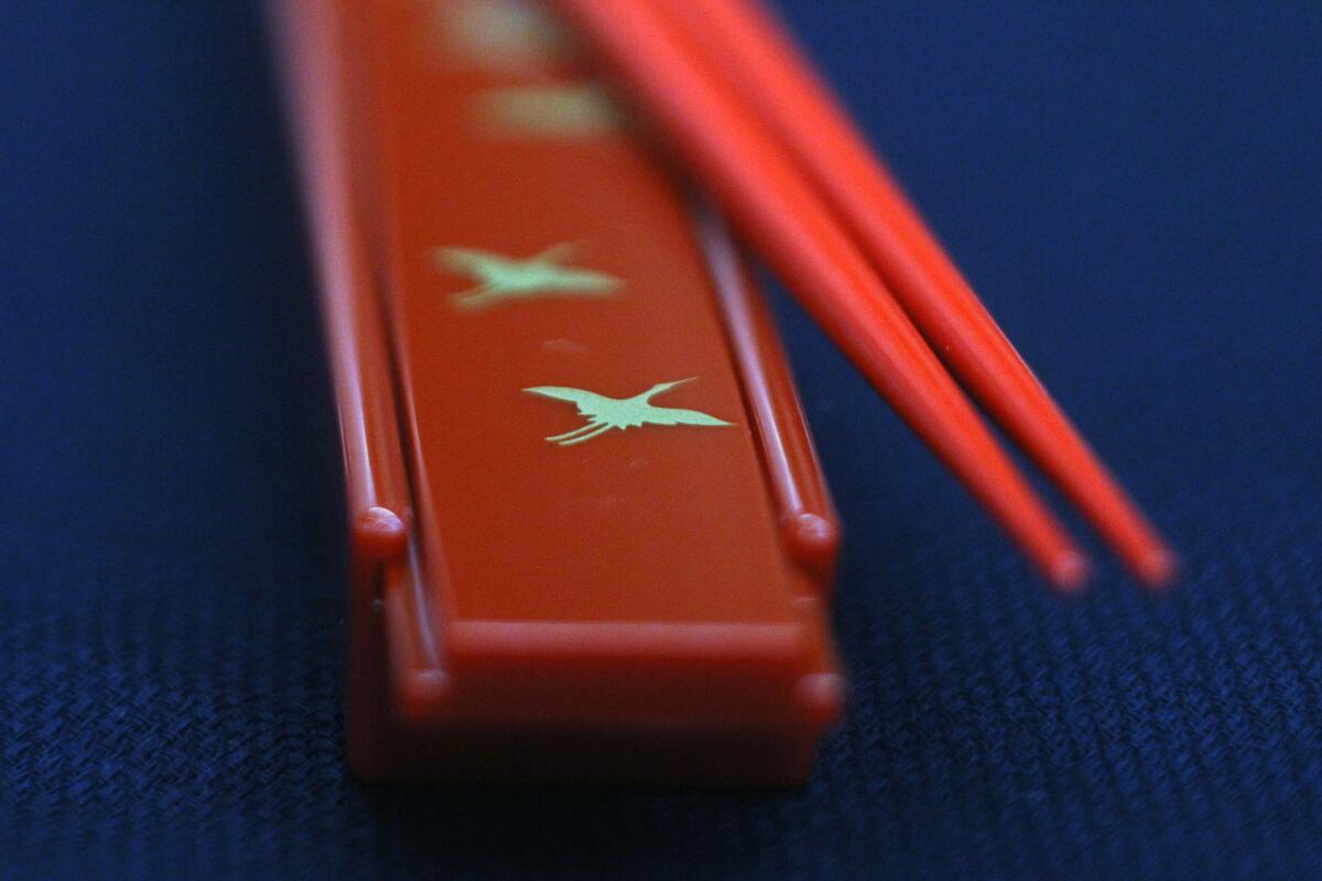 Graceful swans on chopsticks box at Rafu Bussan.