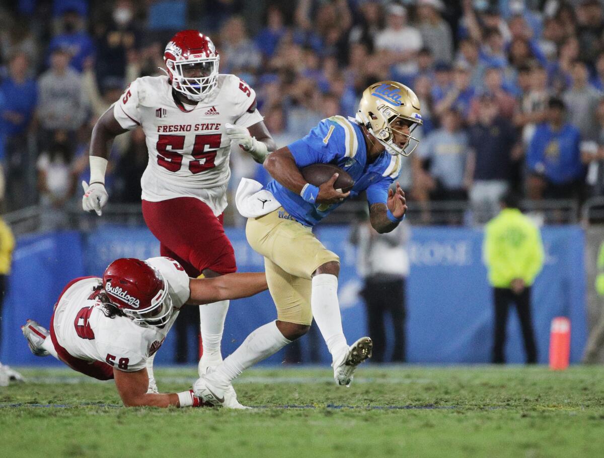 UCLA's Dorian Thompson-Robinson runs with the football past Fresno State players.