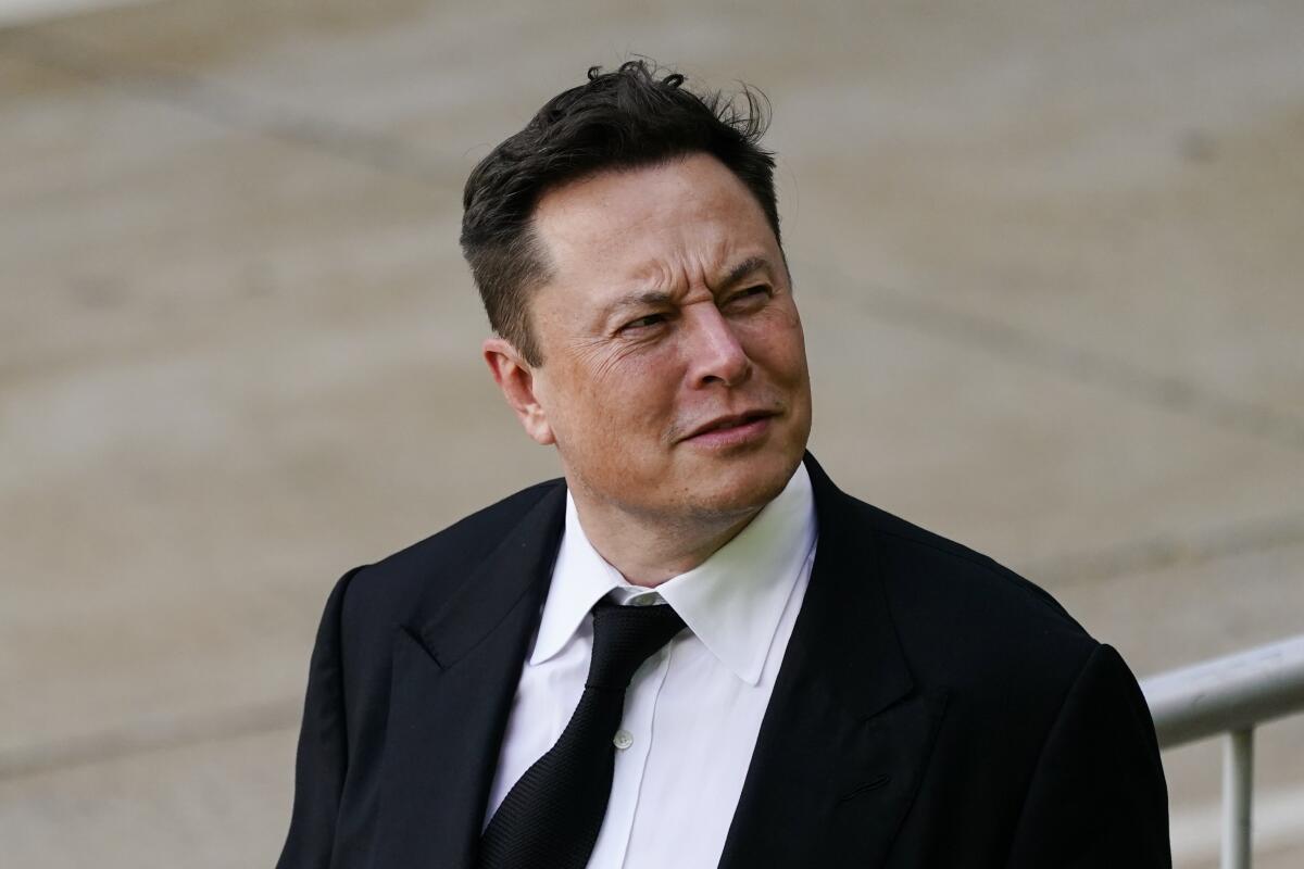Elon Musk walking outside.