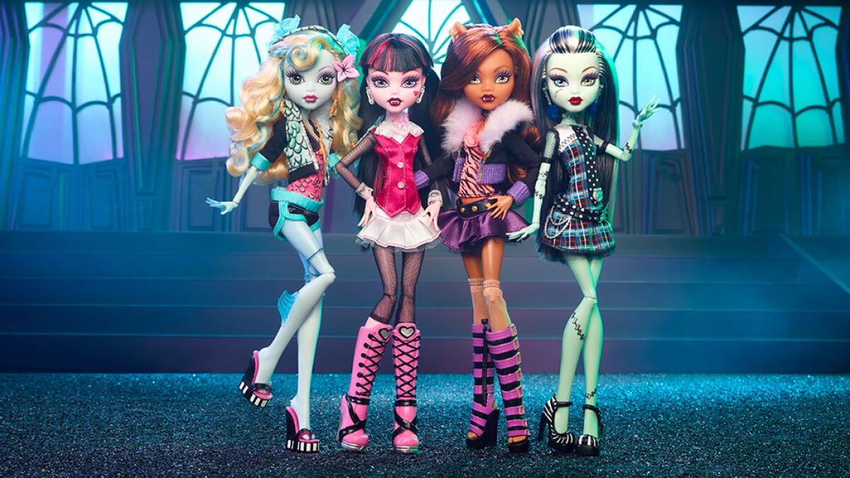 Four plastic girl dolls of varying skin and hair colors wearing colorful, elaborate outfits