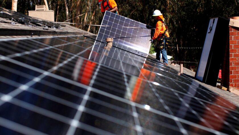 FILE PHOTO: Solar installers from Baker Electric place solar panels on the roof of a residential home in Scripps Ranch, San Diego, California, U.S. October 14, 2016.