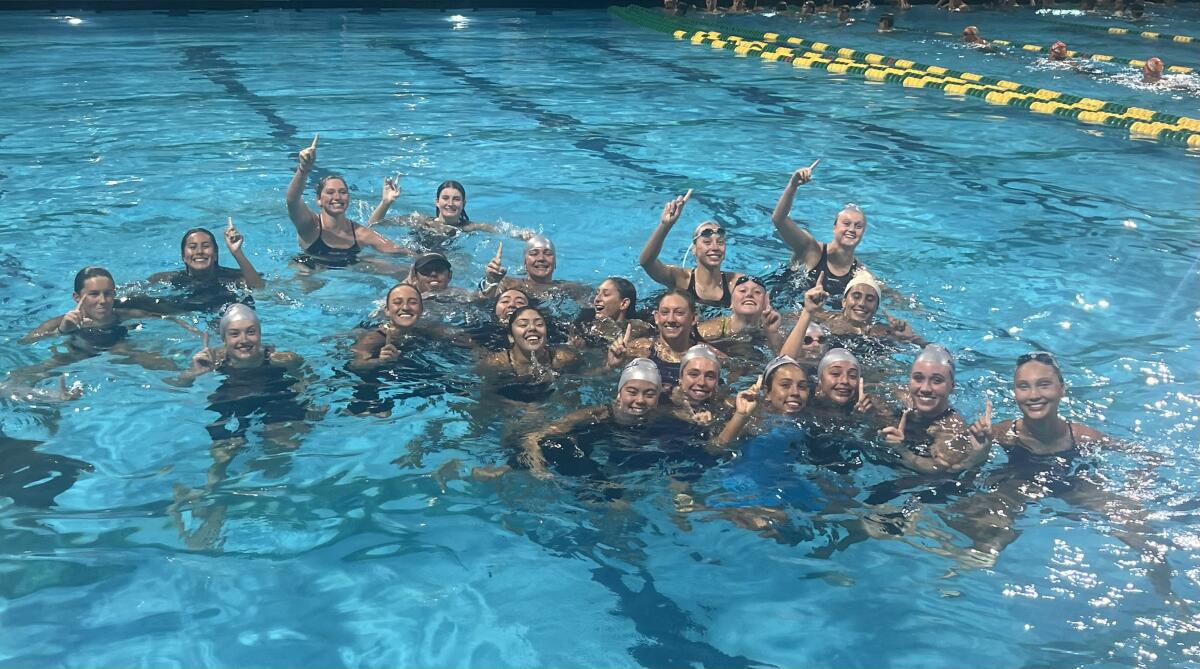 Members of the Newport Harbor girls' swim team celebrate after winning the Surf League title on Friday.