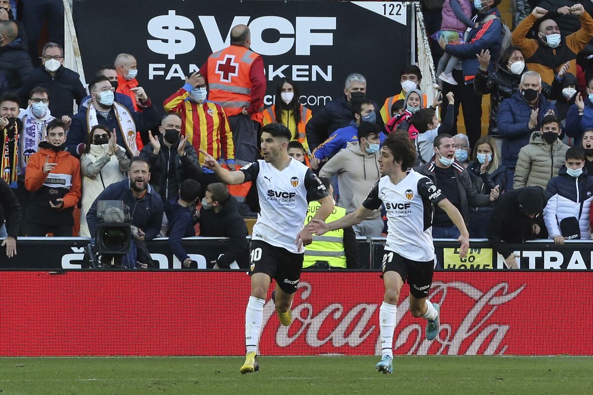 Valencia's Carlos Soler, left, celebrates with Bryan Gil after scoring his side's first goal during a Spanish La Liga soccer match between Valencia and Barcelona at the Mestalla stadium in Valencia, Spain, Sunday, Feb. 20, 2022. (AP Photo/Alberto Saiz)