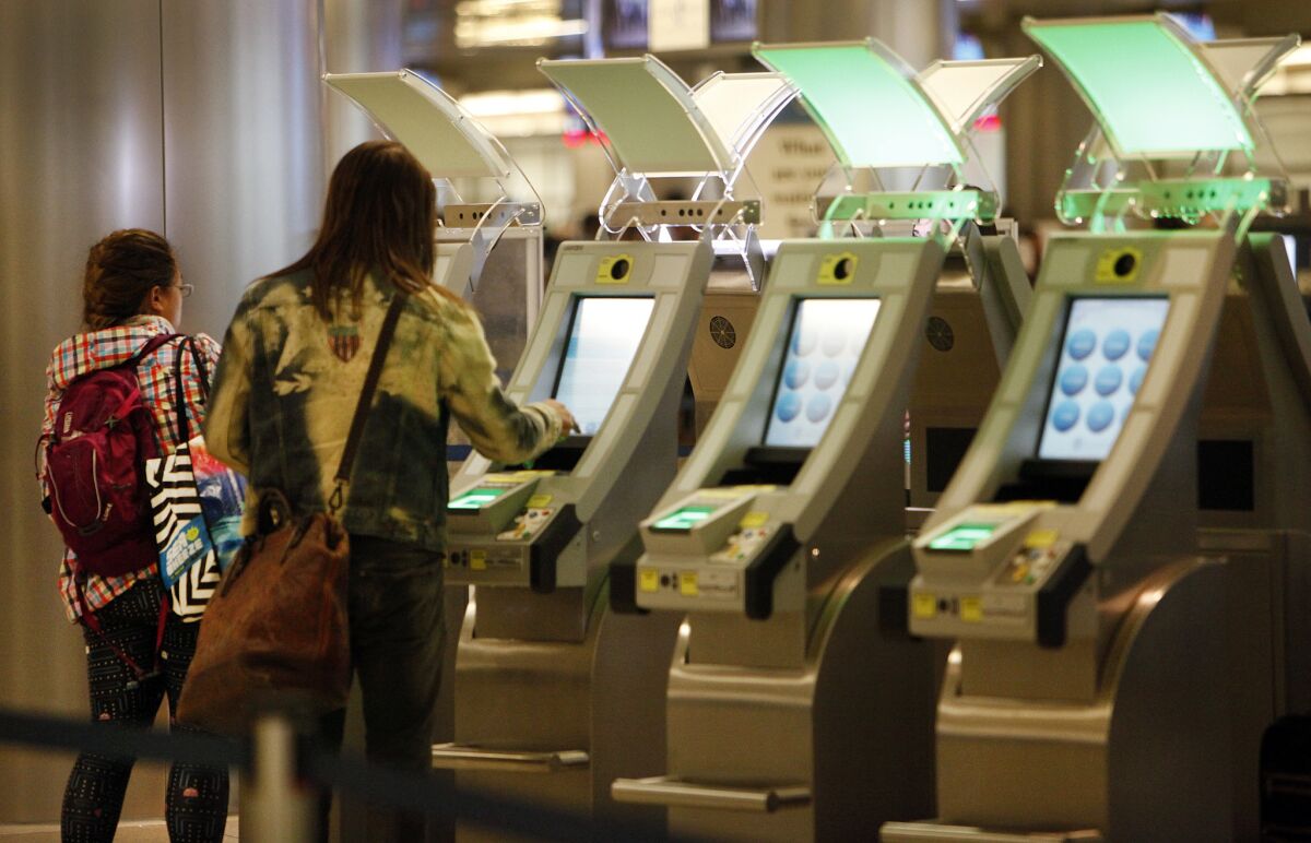 Passengers at the Tom Bradley International Terminal at LAX use the new automated passport-control kiosks that can read passports and customs declarations to expedite entry.