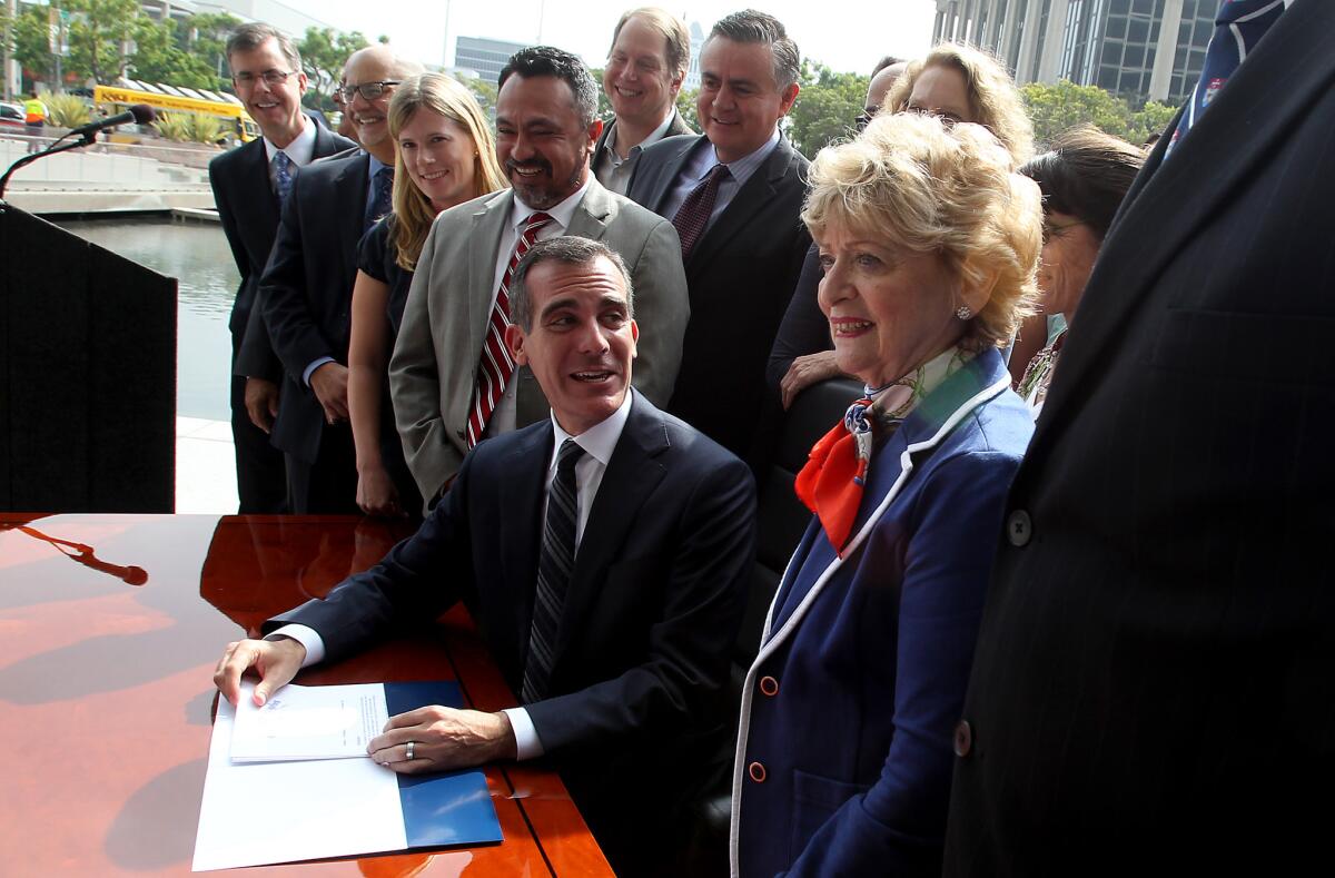 Flanked by city officials and representatives of environmental organizations at the DWP headquarters in Los Angeles, Mayor Eric Garcetti signs a sweeping executive directive on water conservation to address the drought and reduce the city's use of expensive imported water.