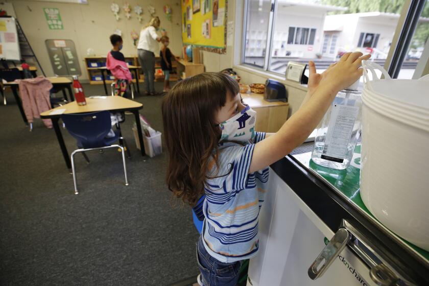 PALOS VERDES, CA - NOVEMBER 05: Kindergarten student Jackson Middleton uses hand sanitizer in the classroom of Kindergarten Teacher Dr. Amanda Hartigan at Chadwick School in Palos Verdes as students are encouraged to use the sanitizer often as they find themselves in smaller class sizes staggered on various days of the week while practicing social distancing and wearing masks. Chadwick is open for kindergarten to second grade with later grades coming back to campus soon. Chadwick School started in 1935. There is wide latitude in terms of how schools can bring kids back to campus In LA County. One option is waivers, while the other is a stipulation that allows schools to bring back 25% of their populations if the students are high needs. Smaller school districts and private schools in more affluent areas are taking advantage of it in greater ways than school districts, raising another set of equity concerns around what children are getting in-person education sooner. Chadwick School on Thursday, Nov. 5, 2020 in Palos Verdes, CA. (Al Seib / Los Angeles Times