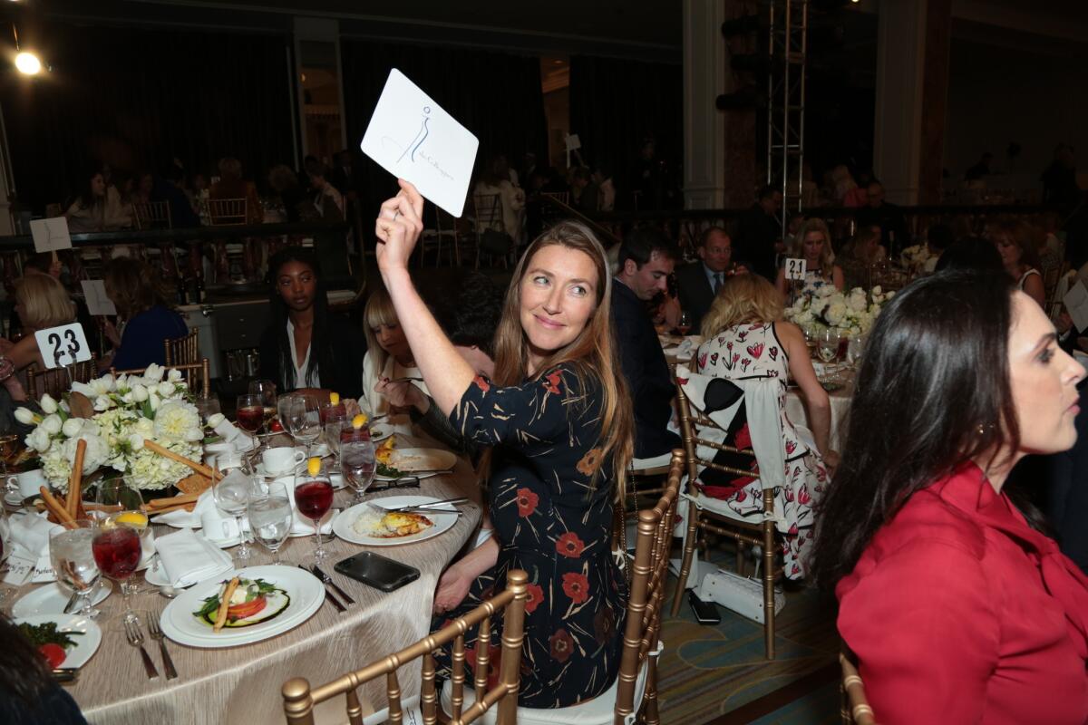 Actress Katherine Flynn, Jane Seymour's daughter, bids during the live auction at the Colleagues' 30th annual spring luncheon and Oscar de la Renta fashion show at the Beverly Wilshire Hotel.