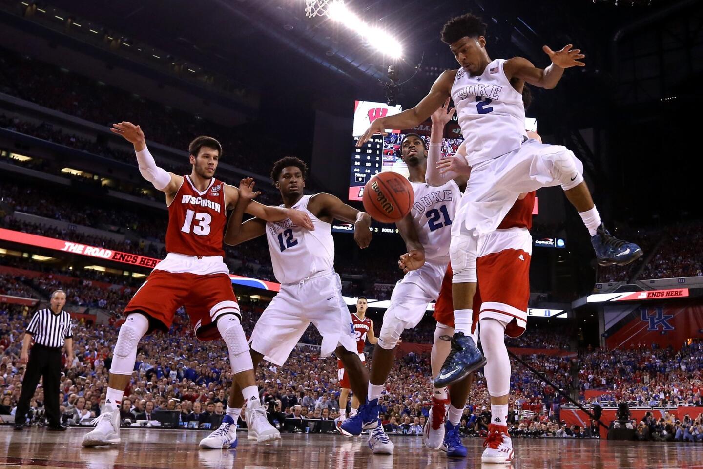 Duke's Quinn Cook goes for a loose ball against Frank Kaminsky in the second half.