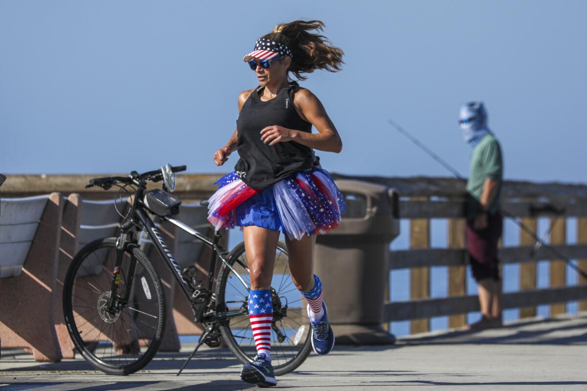On the morning of July 4, Tita Jaramillo runs on Balboa Pier dressed in red, white and blue.
