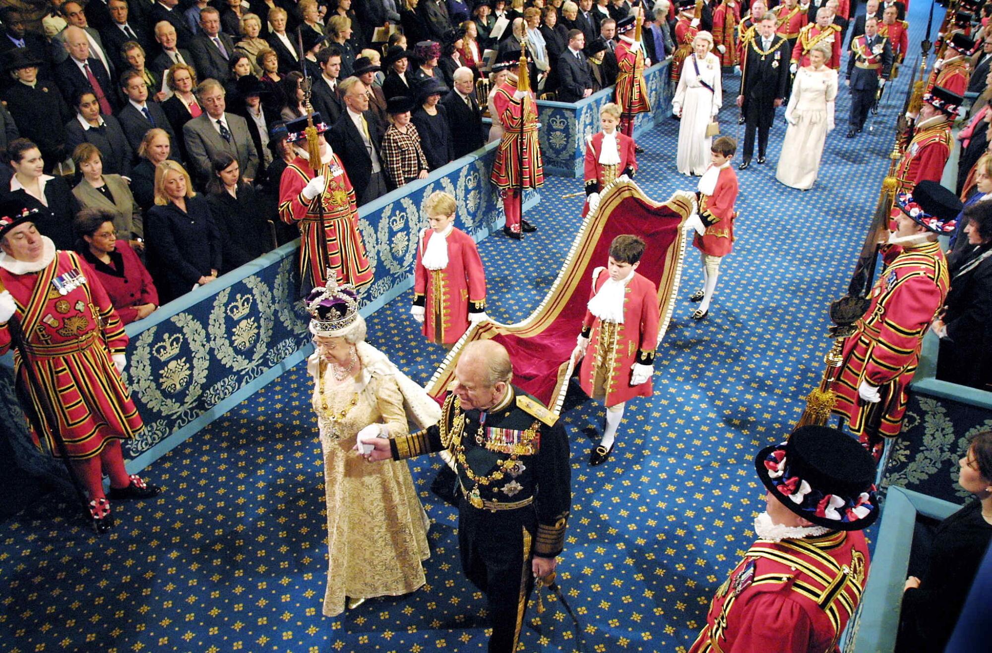 Queen Elizabeth II holds the arm of Prince Philip at a ceremonial occasion